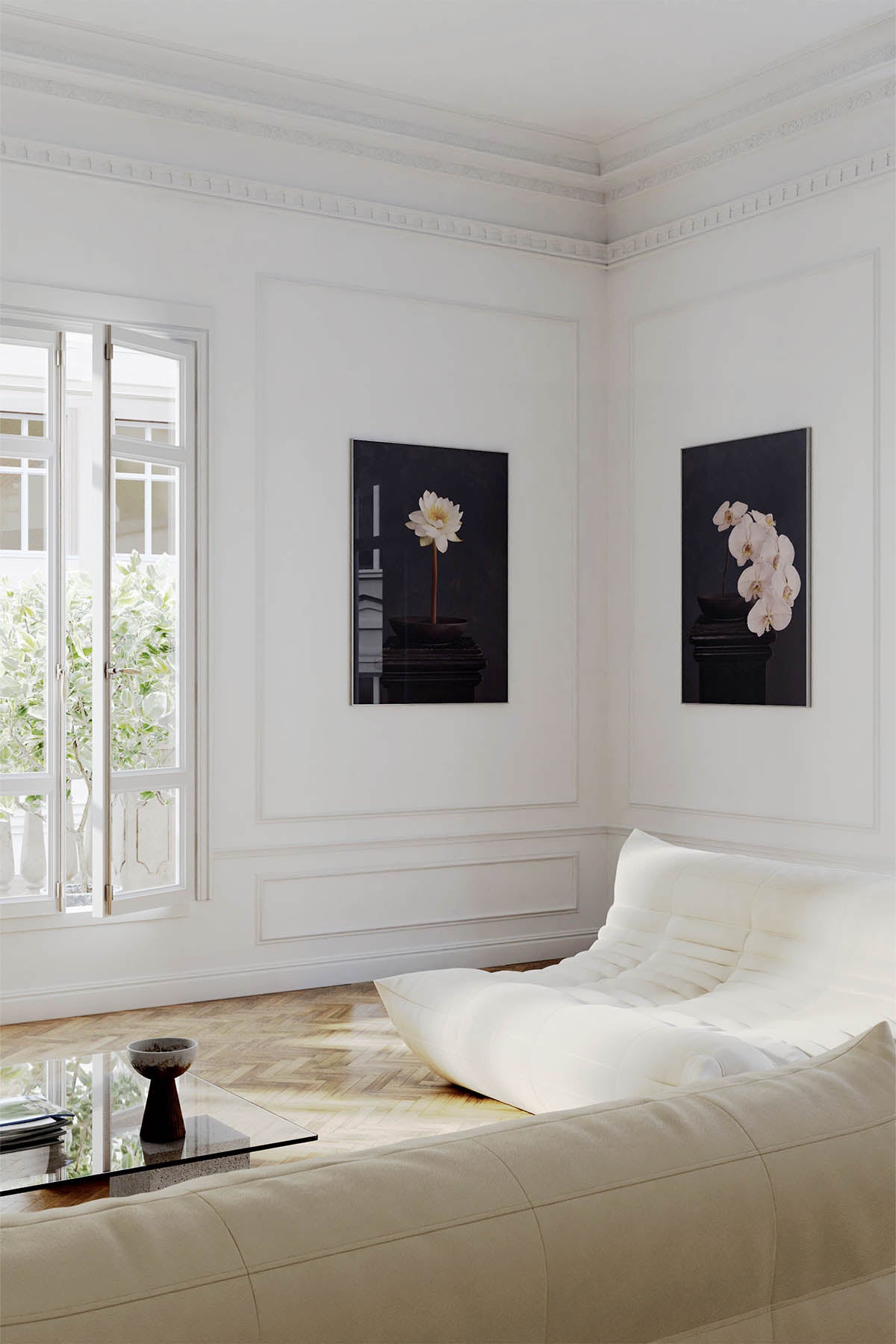 Fine Art Print Of A White Phaleanopsis Stem In A Black Bowl On A Black Mantle Next To An Art Print Of A Water Lily Stem In the same setting With Ling Roset Couches and a french balcony.