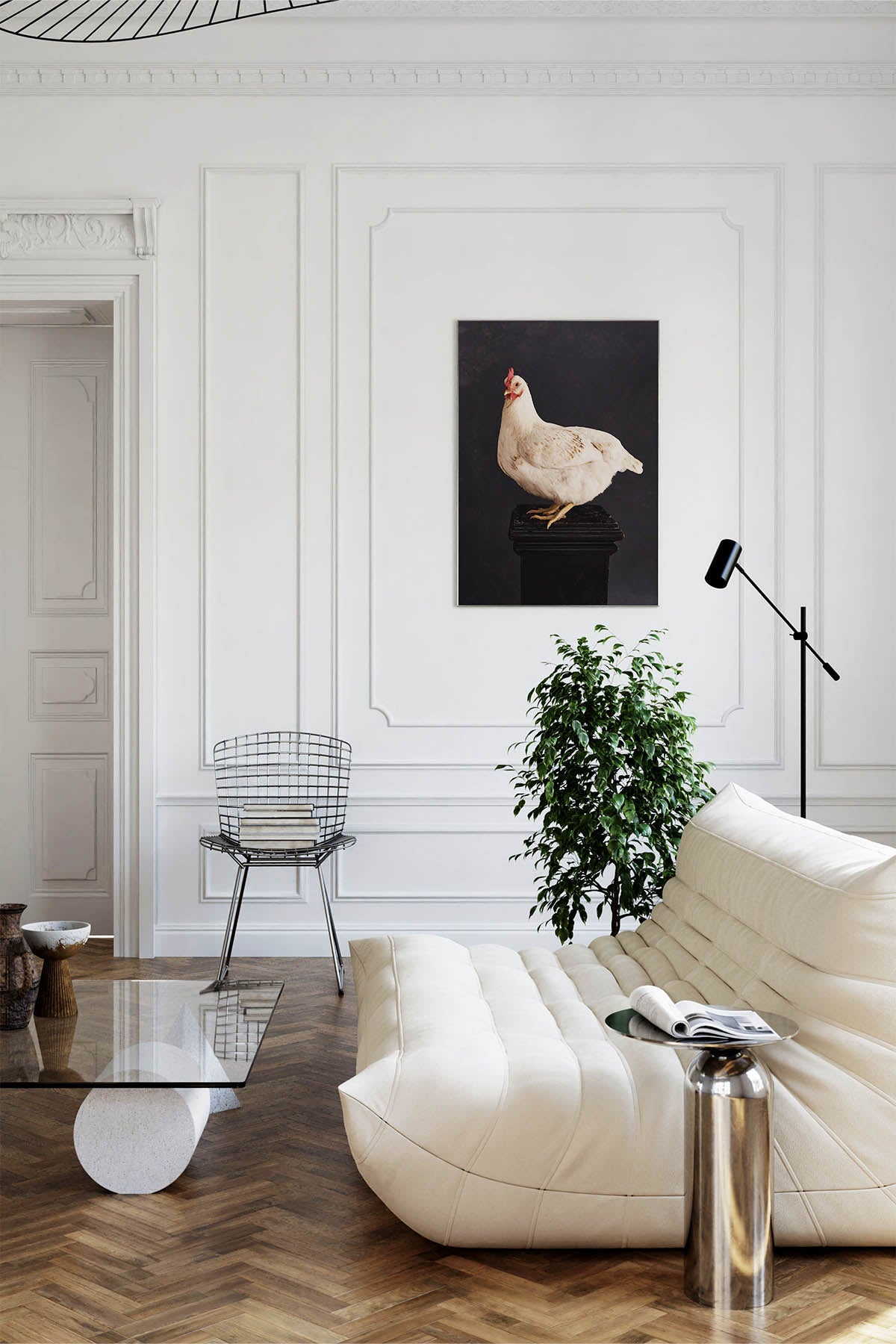 Fine Art Print Of A White Chicken Standing On A Black Plinth With A Black Background Framed On A Wall In An European Style Entry Way or Living Room Near A Harry Bertoia Mid Century Wire Chair and Cream Linge Roset Couch.