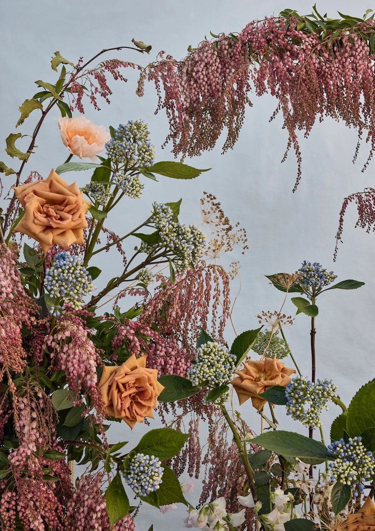 Fine art print of romantic floral arrangement with peach roses, cascading pink amaranthus, and soft blue hydrangeas against a dreamy pale sky backdrop