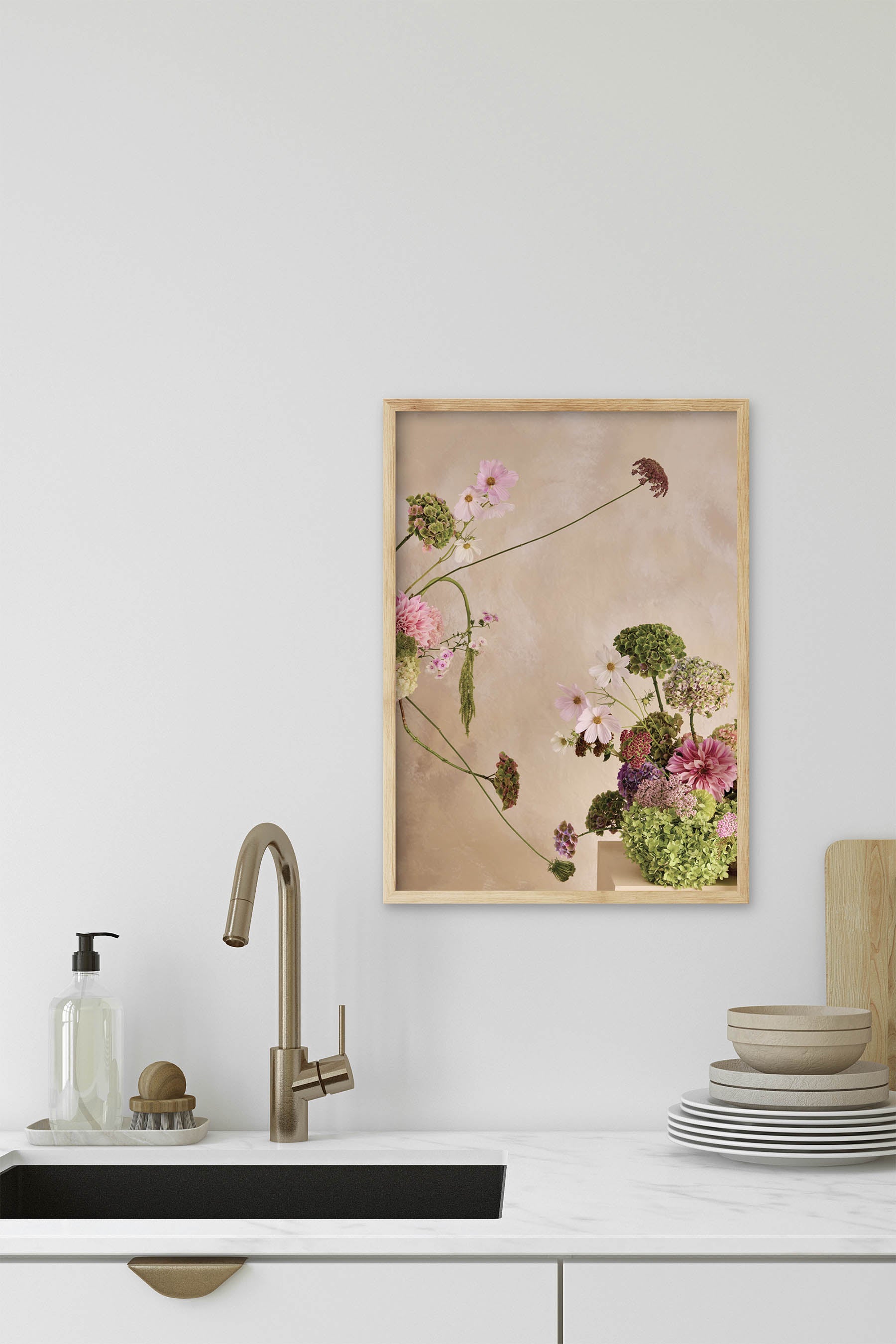 Whimsical Floral Abstract Arrangement against a Linen colour hand painted background Fine Art Print By Austin Bloom size A3 framed in a light oak timber fame in a modern kitchen with a white marble countertop and aged brass hardware.
