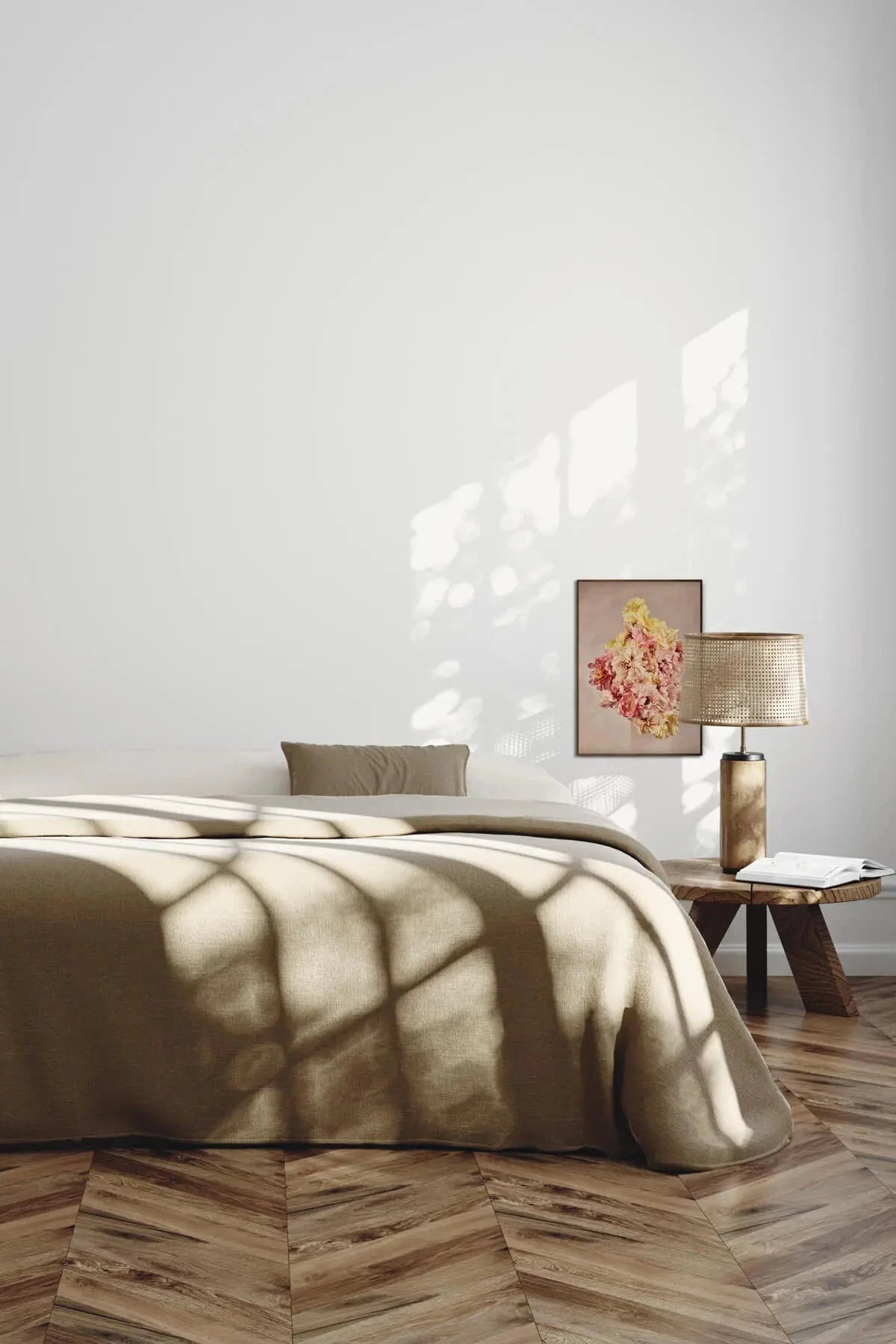 Fine art print of pink and yellow peonies on blush background beside brass lamp in sunlit bedroom with olive linen bedding