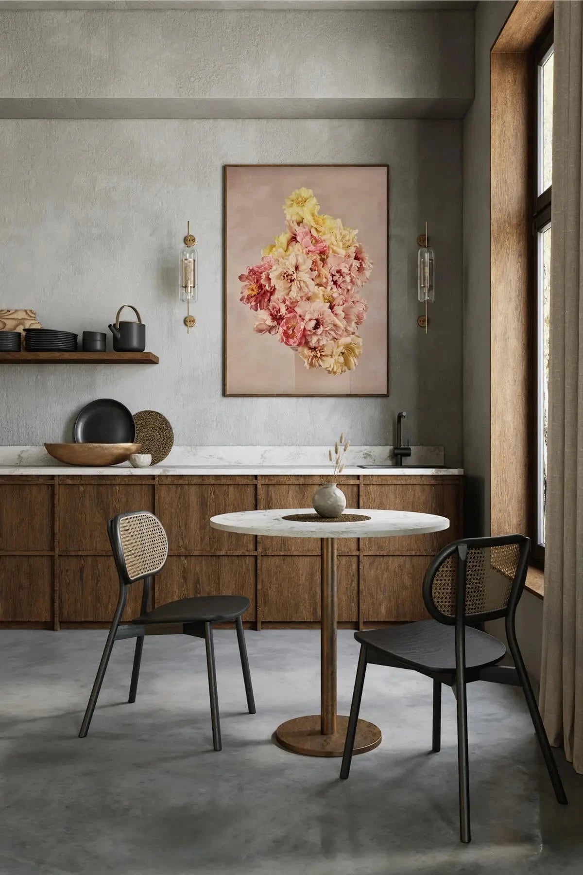 Botanical art print of pink and yellow peonies on blush background hanging above marble dining table in sophisticated kitchen with timber cabinetry