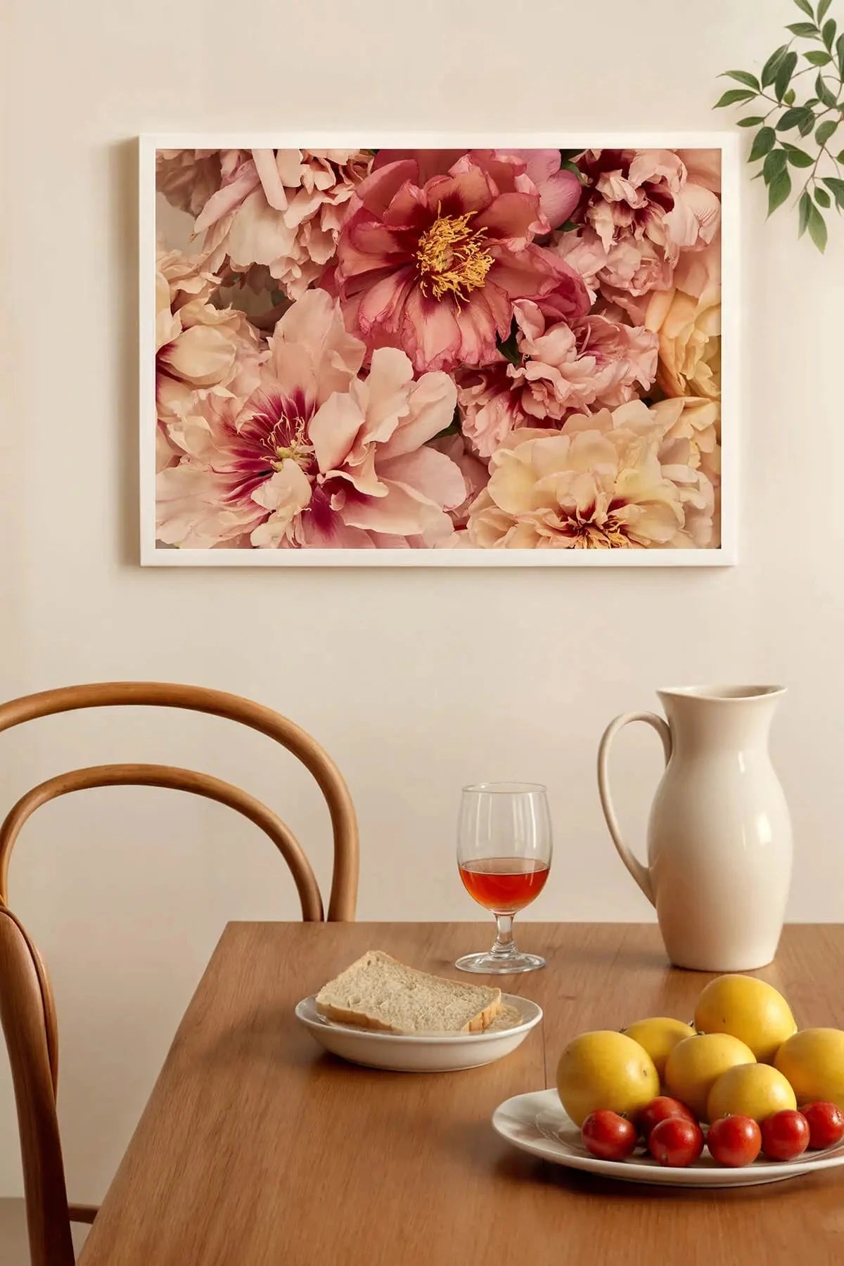 Fine art print of lush pink and cream peonies with golden centers above a dining table with fresh lemons and Mediterranean setting