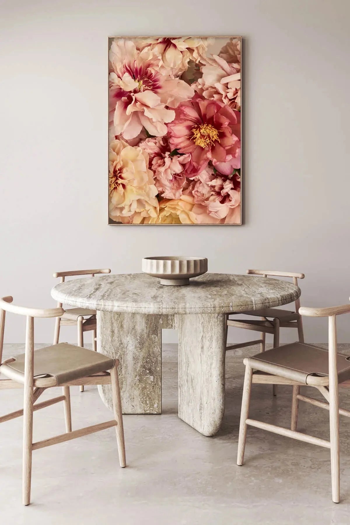 Botanical art print of lush pink and cream peonies with golden stamens hanging above a marble dining table in a minimalist neutral interior
