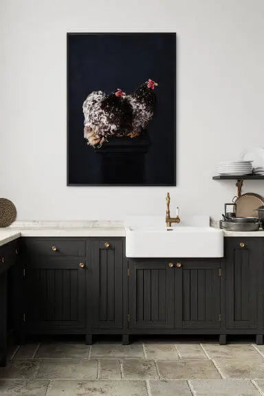 Fine art print of white hydrangeas with pink blooms on moody black background displayed above marble vanity with dark green cabinetry and brass fixtures